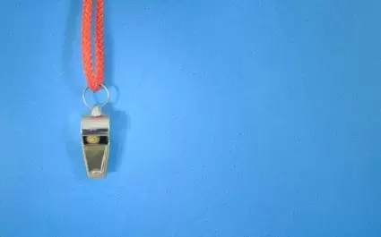 whistle hanging on blue background with red rope