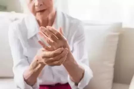 Older women holding hand with arthritis pain