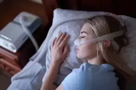 Women sleeping with recalled philips cpap machine mask on