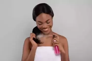Young black female using hair straightener products or products for straightened hair.