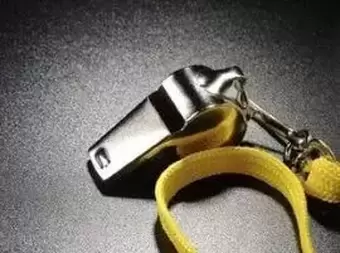 Whistle laying on hard surface face up with a yellow band