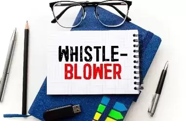 whistle blower in black and red on white note pad on table with pens and pencils