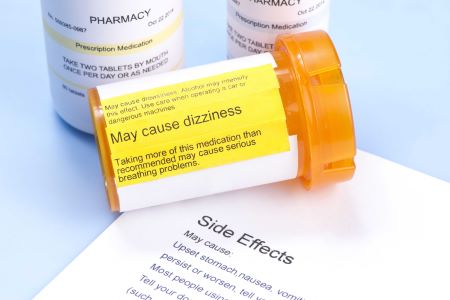 Picture of medicine bottle and paper reading side effects